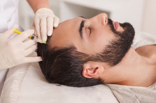 ein Mann bekommt eine Injektion zur Haarwiederherstellung