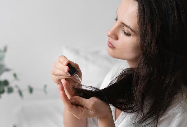 Frau macht eine Selbstpflegebehandlung, um nach einer Haartransplantation das Haarwachstum zu fördern