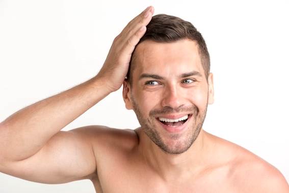 mann schaut in den spiegel nach einer haartransplantation - haartransplantation kosten