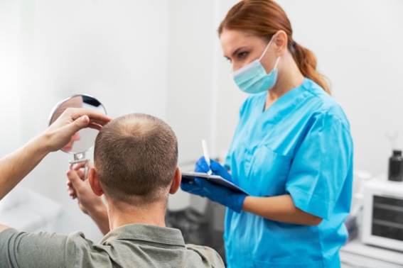 Patientin schaut in den Spiegel und befragt den Arzt nach einer Haartransplantation Türkei